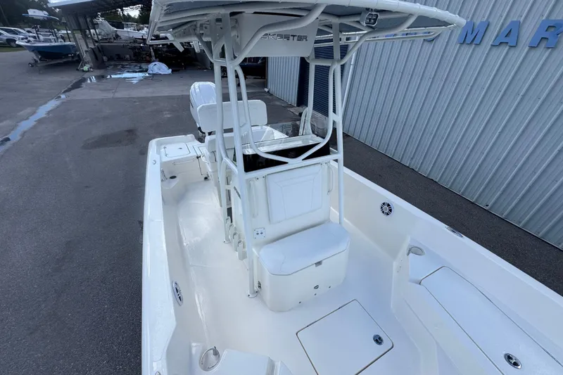 Slide: The Image of 2026 Skeeter SX2350 boat with T-top and seating, docked near a marina. - 7