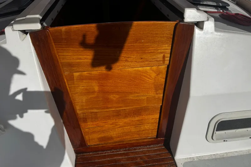 Slide: The Image of 1984 Hunter 37 Cutter sailboat with polished wooden hatch and shadow silhouette. - 17