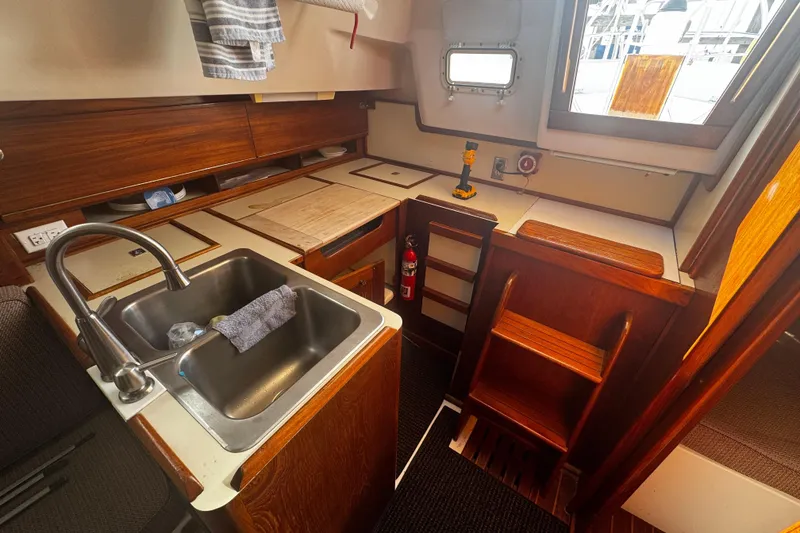 Slide: The Image of 1984 Hunter 37 Cutter yacht kitchen with wooden cabinetry and stainless steel sink. - 20
