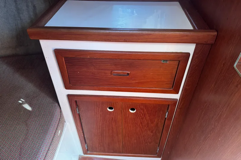 Slide: The Image of Wooden cabinetry inside a 1984 Hunter 37 Cutter sailboat, featuring a drawer and cupboard. - 22