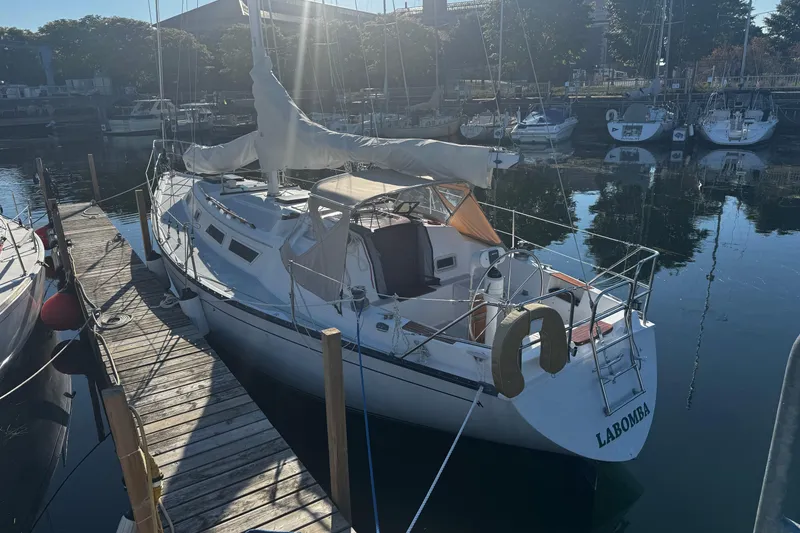 Slide: The Image of 1984 Hunter 37 Cutter sailboat docked in a marina, sunlight reflecting on water. - 3