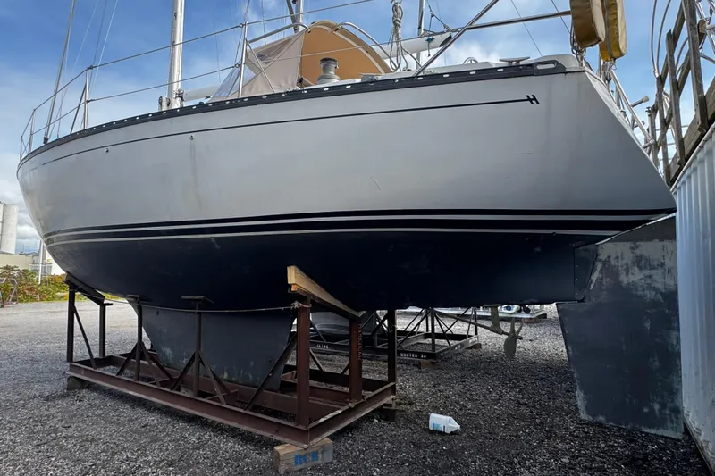 Slide: The Image of 1984 Hunter 37 Cutter sailboat on dry dock, showcasing hull and keel. - 36