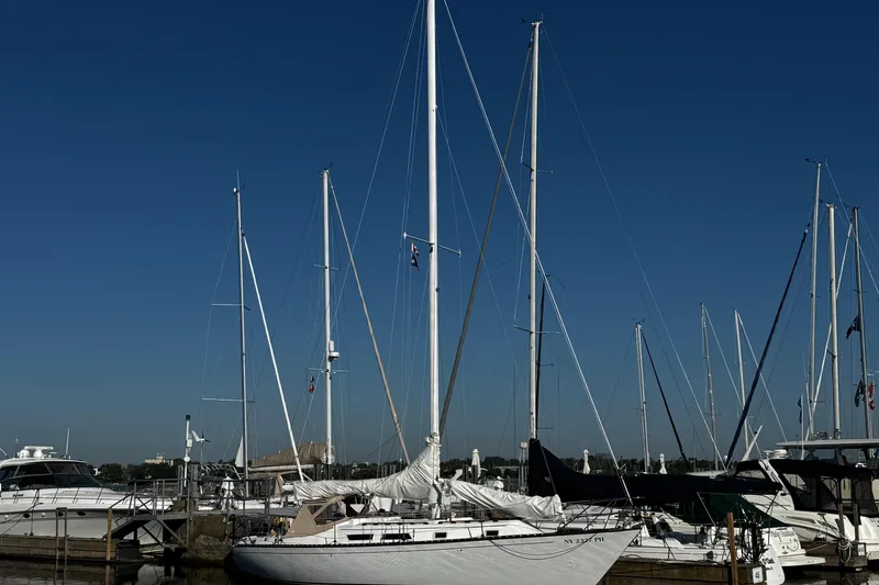 Slide: The Image of 1984 Hunter 37 Cutter sailboat docked at marina under clear blue sky. - 1