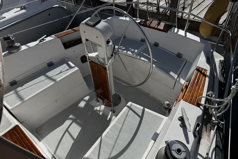 Slide: The Image of 1984 Hunter 37 Cutter sailboat cockpit with steering wheel and wooden accents. - 10