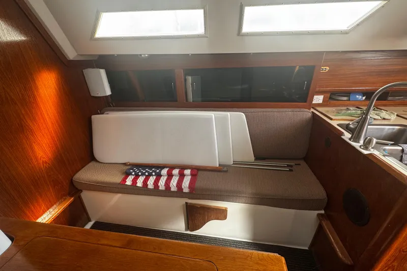 Slide: The Image of Interior of 1984 Hunter 37 Cutter sailboat with seating and American flag. - 19