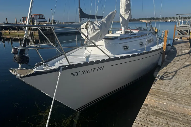 Slide: The Image of 1984 Hunter 37 Cutter sailboat docked at marina, clear sky, calm water. - 2