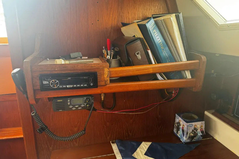 Slide: The Image of Navigation station on 1984 Hunter 37 Cutter with radio, books, and accessories. - 24