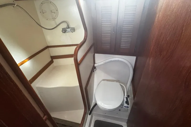 Slide: The Image of 1984 Hunter 37 Cutter yacht bathroom with toilet and shower area. - 27