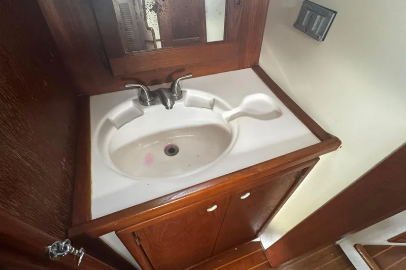 Slide: The Image of 1984 Hunter 37 Cutter bathroom sink with wooden cabinet and mirror. - 28