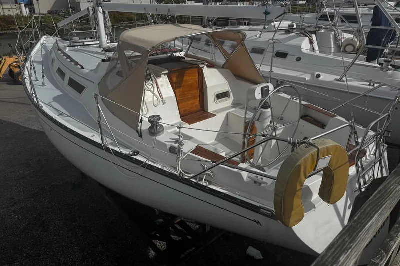 Slide: The Image of 1984 Hunter 37 Cutter sailboat docked, featuring a spacious cockpit and classic design. - 7