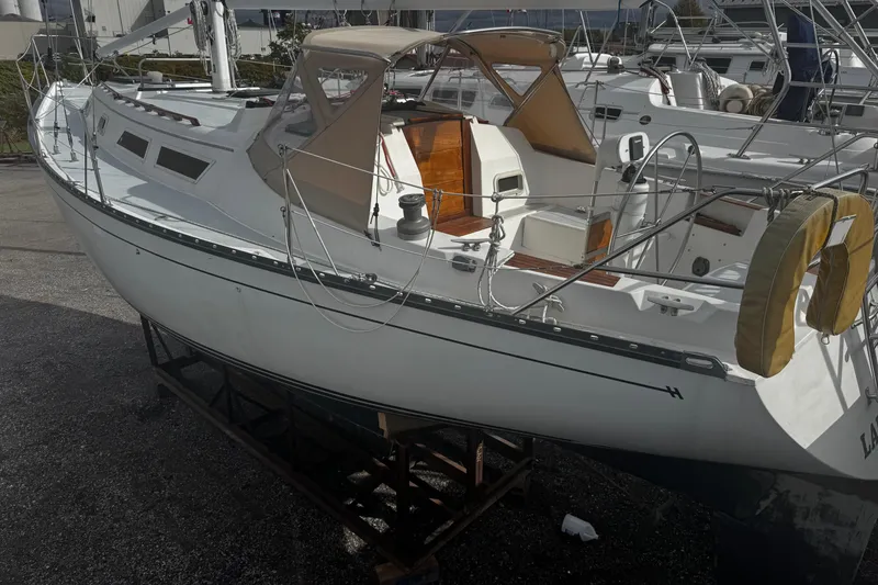 Slide: The Image of 1984 Hunter 37 Cutter sailboat on dry dock, featuring a spacious cockpit and sleek design. - 8