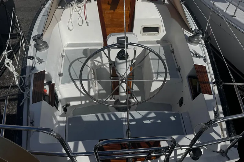 Slide: The Image of 1984 Hunter 37 Cutter sailboat cockpit with steering wheel and seating area. - 9