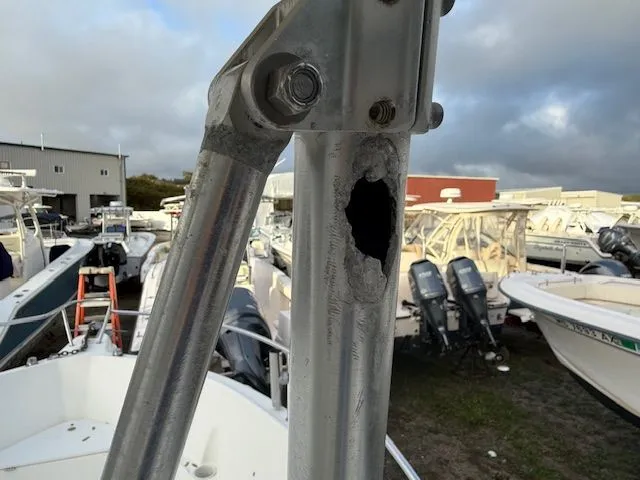 Slide: The Image of Damaged metal pole on 2003 Aquasport Osprey 205 boat, surrounded by other boats in a yard. - 13