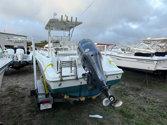 Slide: The Image of 2003 Aquasport Osprey 205 boat with outboard motor, parked on a trailer. - 2