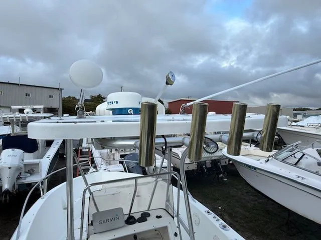 Slide: The Image of 2003 Aquasport Osprey 205 boat with rod holders and Garmin equipment, docked under cloudy skies. - 3