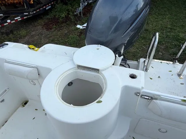 Slide: The Image of 2003 Aquasport Osprey 205 boat with open storage compartment and outboard motor. - 5