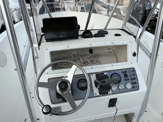 Slide: The Image of 2003 Aquasport Osprey 205 boat dashboard with steering wheel, gauges, and navigation equipment. - 6