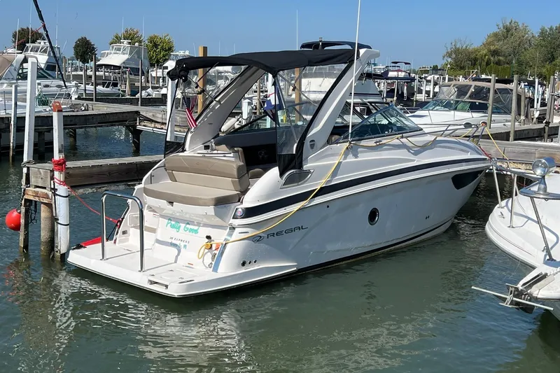 The Image of 2014 Regal 28 Express boat docked at a marina on a sunny day. - 1