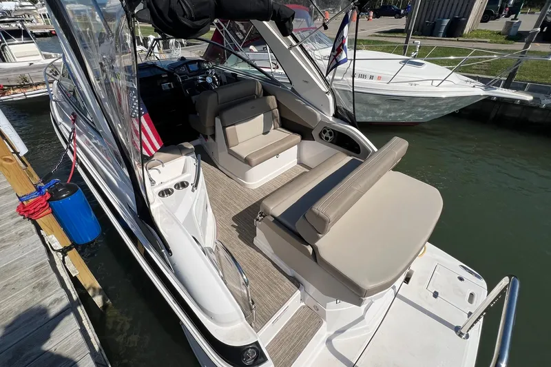 Slide: The Image of 2014 Regal 28 Express boat docked, featuring spacious seating and sleek design. - 11