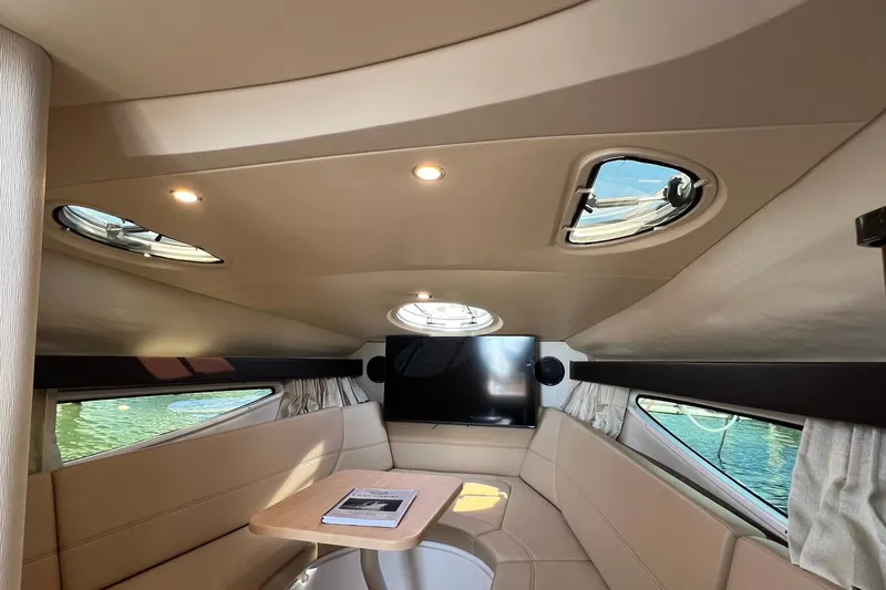 Slide: The Image of Interior of 2014 Regal 28 Express boat with seating, table, and windows. - 13