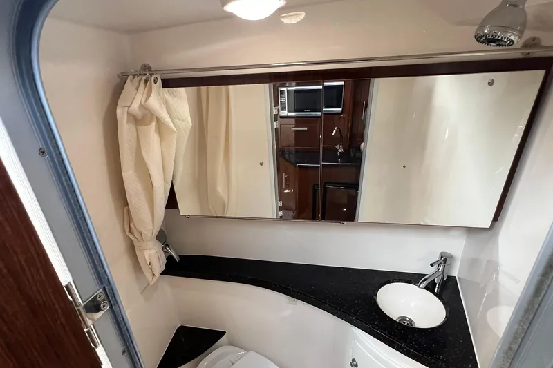 Slide: The Image of 2014 Regal 28 Express boat bathroom with mirror, sink, and showerhead. - 15