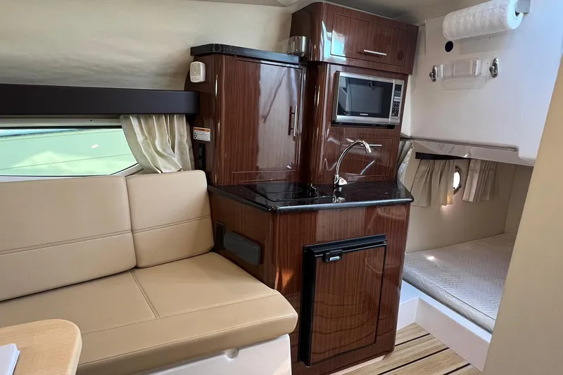 Slide: The Image of Interior of 2014 Regal 28 Express boat with kitchenette and seating area. - 18