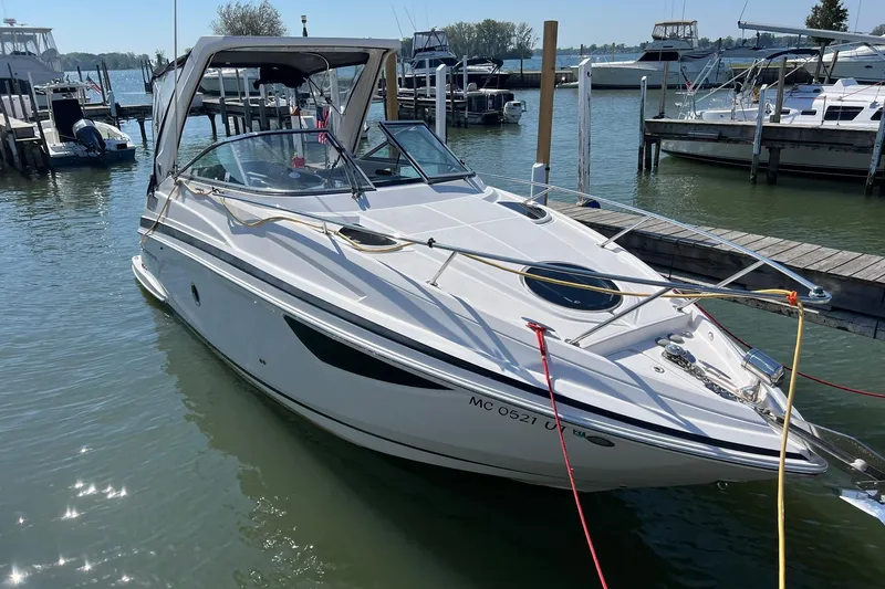 Slide: The Image of 2014 Regal 28 Express boat docked in a marina under clear skies. - 2