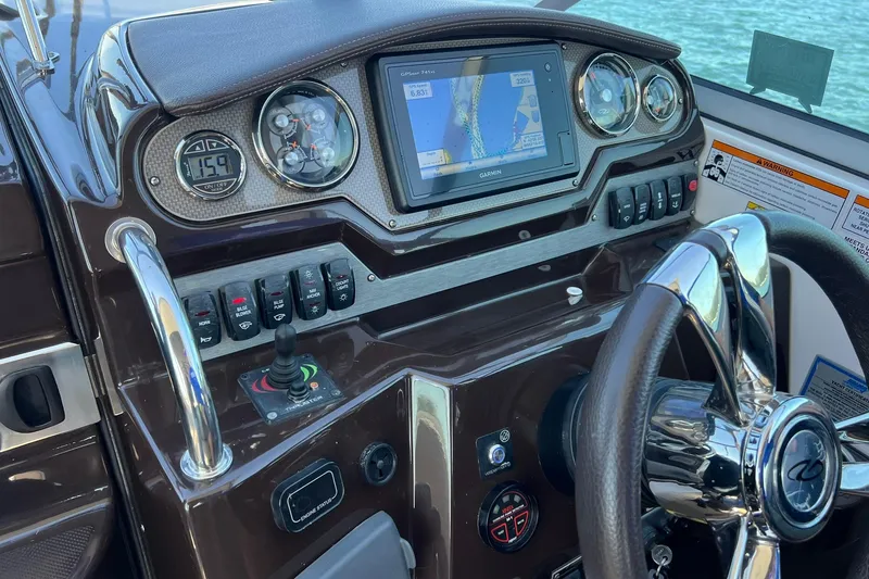 Slide: The Image of Control panel of a 2014 Regal 28 Express boat with navigation system and steering wheel. - 24
