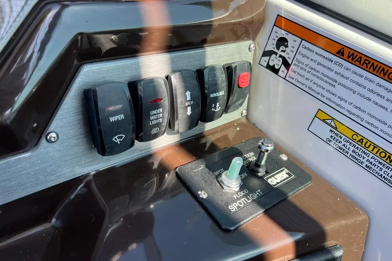 Slide: The Image of Control panel of a 2014 Regal 28 Express boat with warning labels. - 28