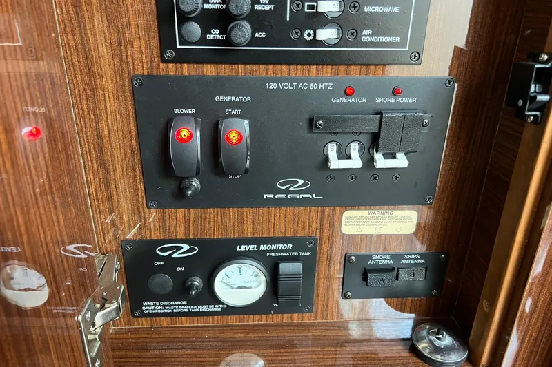 Slide: The Image of Control panel of a 2014 Regal 28 Express boat with generator and power switches. - 30