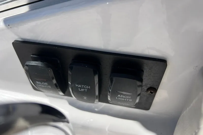 Slide: The Image of Control panel with switches for bilge lights, hatch lift, and arch lights on a 2014 Regal 28 Express. - 35