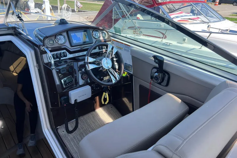 Slide: The Image of 2014 Regal 28 Express boat cockpit with steering wheel and navigation system. - 36