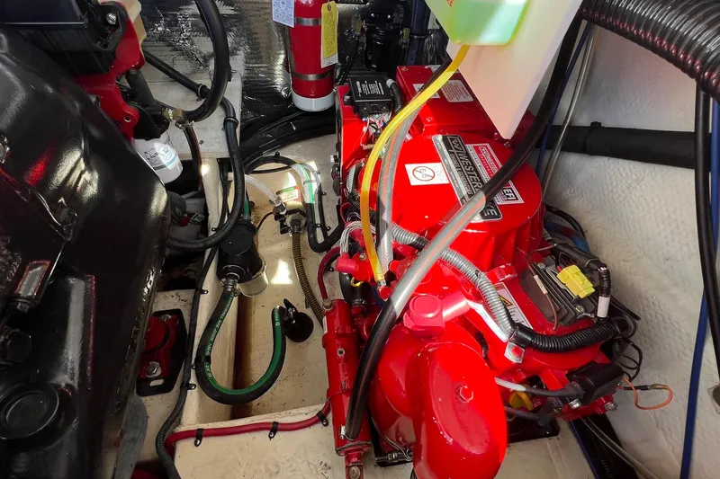 Slide: The Image of Engine compartment of a 2014 Regal 28 Express boat, featuring a red engine and wiring. - 38