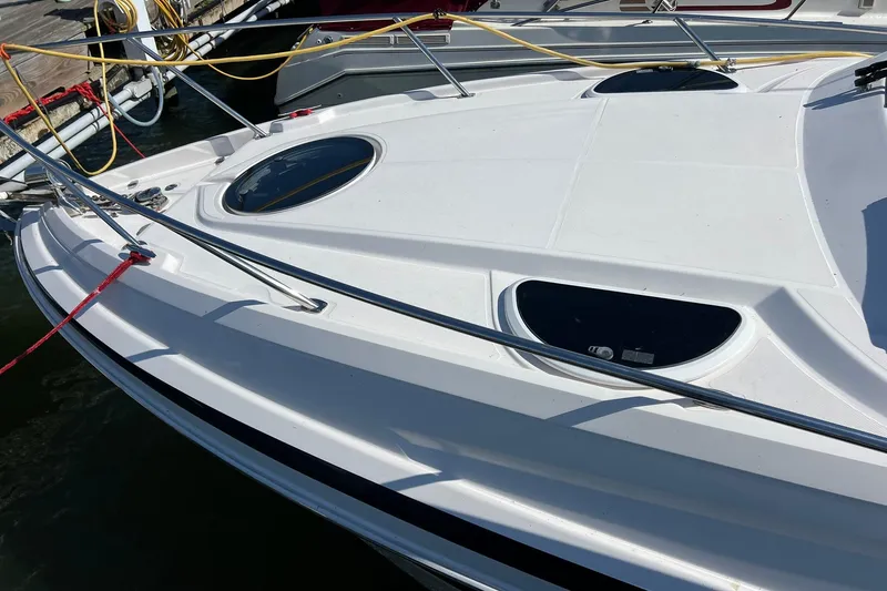 Slide: The Image of 2014 Regal 28 Express boat docked, featuring sleek white deck and stainless steel railings. - 4