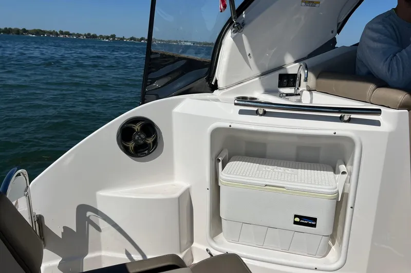 Slide: The Image of 2014 Regal 28 Express boat interior with cooler and speaker, on a sunny day at sea. - 6