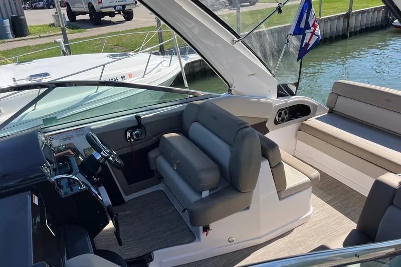 Slide: The Image of 2014 Regal 28 Express boat interior with helm, seating, and waterfront view. - 8