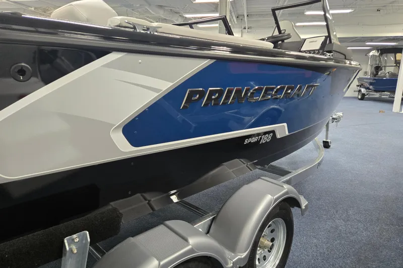 Slide: The Image of 2026 Princecraft Sport 188 boat on trailer, blue and white design, indoor showroom. - 1