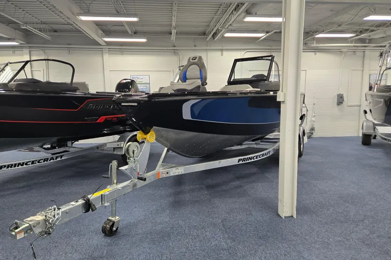 Slide: The Image of 2026 Princecraft Sport 188 boat on display in showroom, blue and black design. - 2