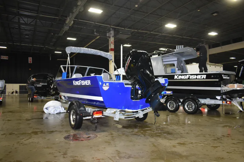 Slide: The Image of 2026 KingFisher 1825 Falcon boat displayed indoors with powerful outboard motor. - 13