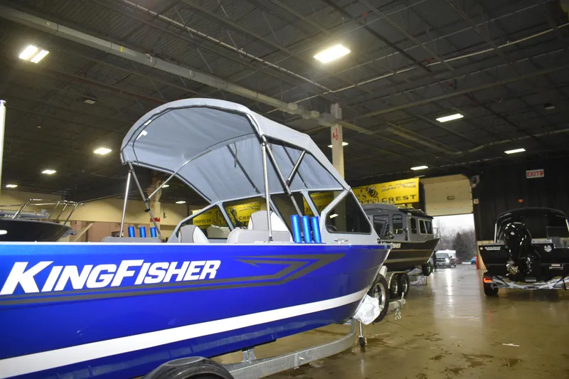Slide: The Image of 2026 KingFisher 1825 Falcon boat displayed indoors, featuring a sleek blue design. - 15