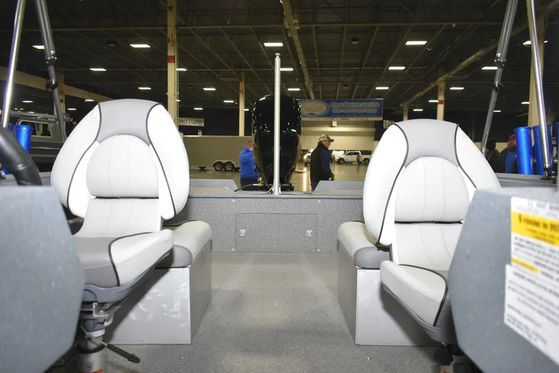 Slide: The Image of Interior of 2026 KingFisher 1825 Falcon boat with two white seats in a showroom. - 21