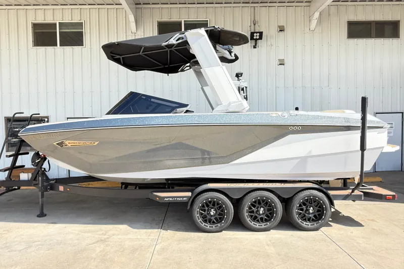Slide: The Image of 2022 Nautique Super Air Nautique G23 boat on trailer, parked outside a building. - 11