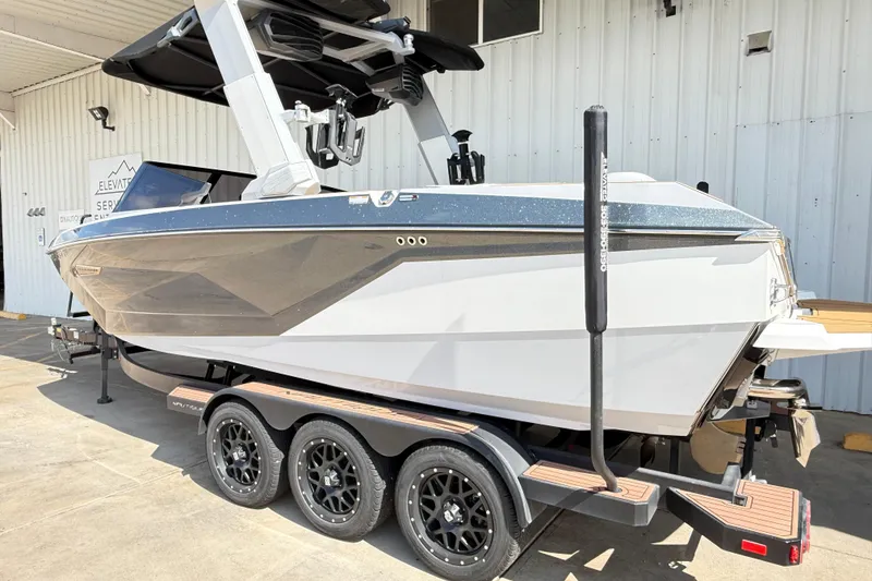 Slide: The Image of 2022 Nautique Super Air Nautique G23 boat on trailer, parked outside a building. - 15