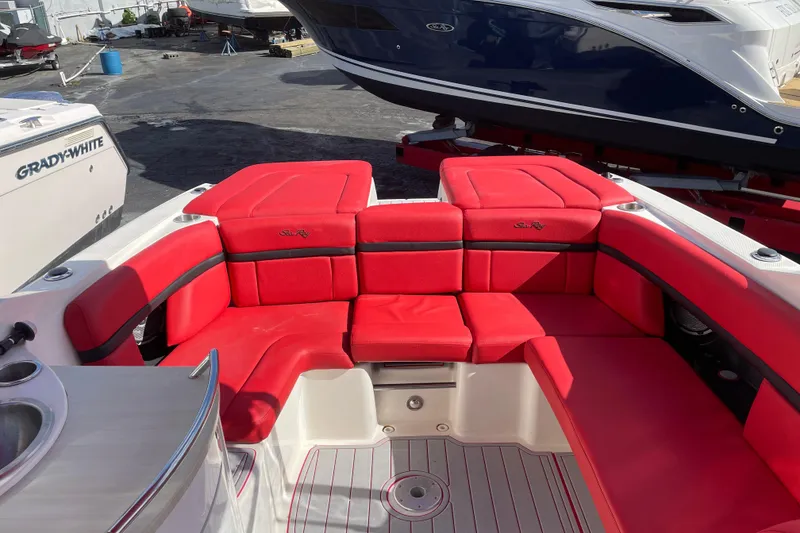 Slide: The Image of 2014 Sea Ray 270 SLX boat with vibrant red seating in a marina setting. - 10