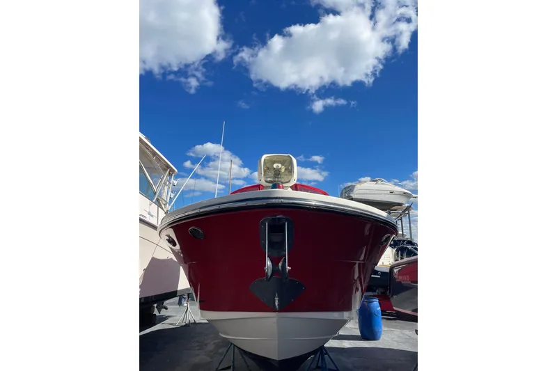 Slide: The Image of 2014 Sea Ray 270 SLX boat with red hull under a bright blue sky. - 15