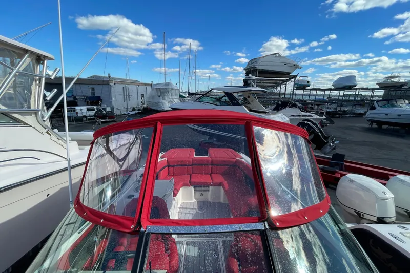 Slide: The Image of 2014 Sea Ray 270 SLX boat with red interior, docked in a marina under a blue sky. - 8