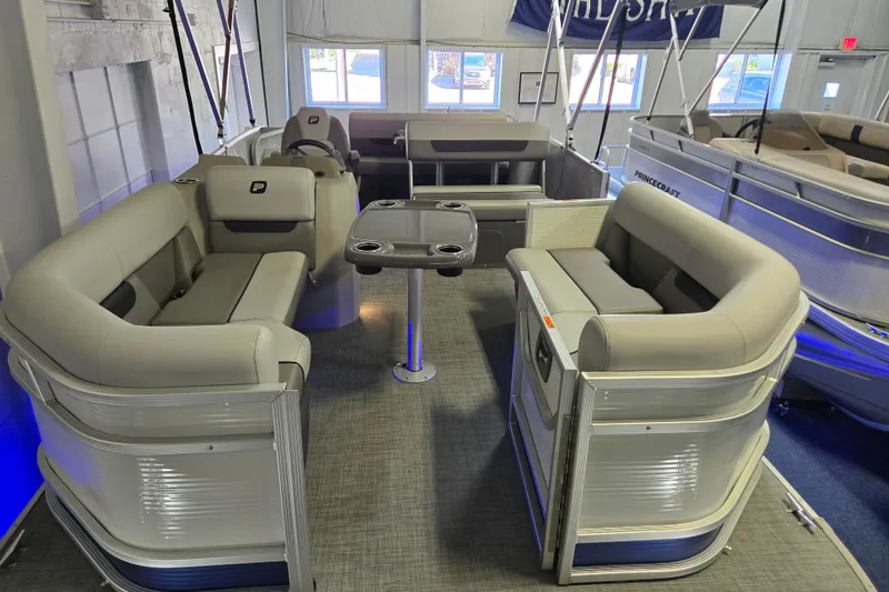 Slide: The Image of 2025 Princecraft Vectra 21 RL pontoon boat interior with plush seating and table. - 10