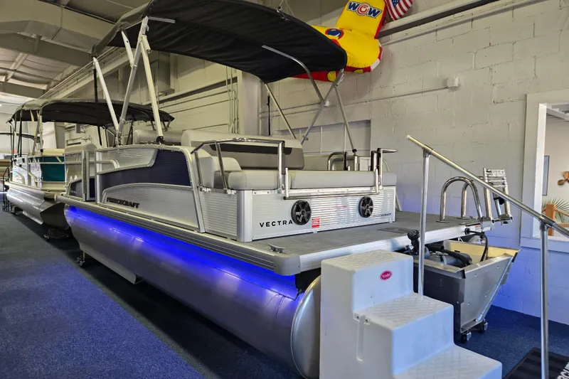 Slide: The Image of 2025 Princecraft Vectra 21 RL pontoon boat with blue LED lights in showroom. - 2
