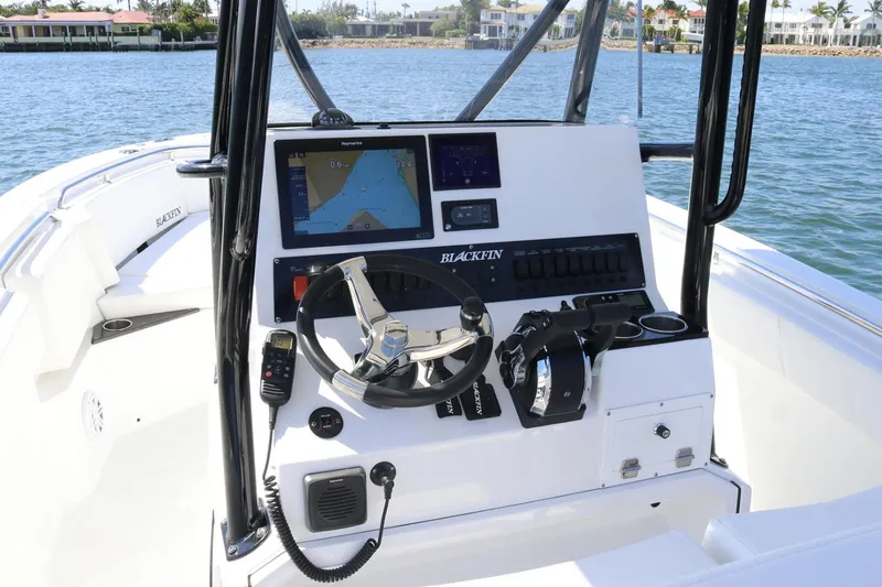 Slide: The Image of Manufacturer Provided Image: 2026 Blackfin 252 CC boat dashboard with navigation system and steering wheel on open water. - 4