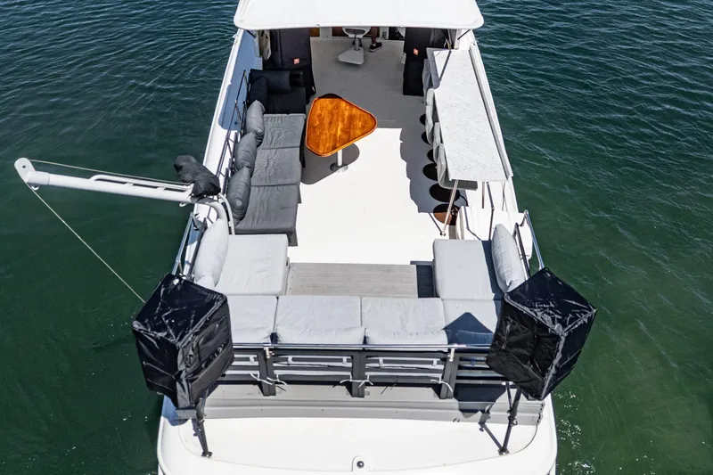 Slide: The Image of 1979 Hatteras 58 Motor Yacht with spacious deck and seating, cruising on water. - 16